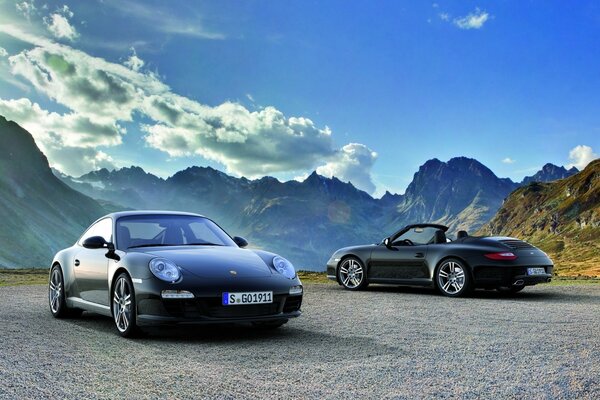 New cars are parked on the asphalt against the backdrop of mountains