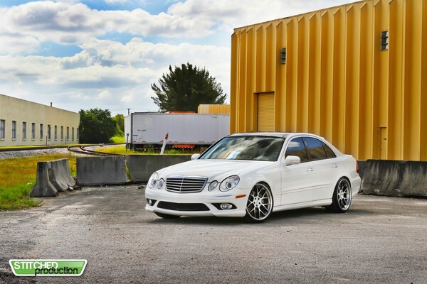 The car at the garage is a white Mercedes