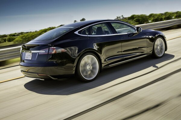 A blue car rushes along the autobahn