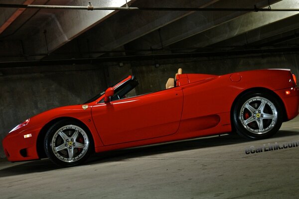 Cabriolet rouge sur fond de parking sombre