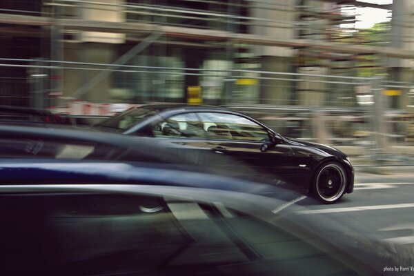 Photo of a fast-moving car on the background of a blurry image of the city