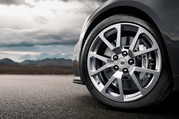 A fragment of a car. Silver wheels of the car