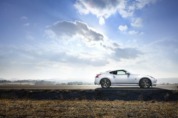 El coche blanco está de pie contra el cielo azul