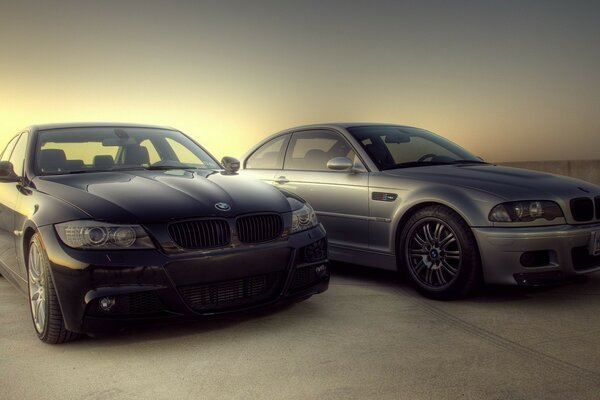 Black and gray cars are standing on gray asphalt