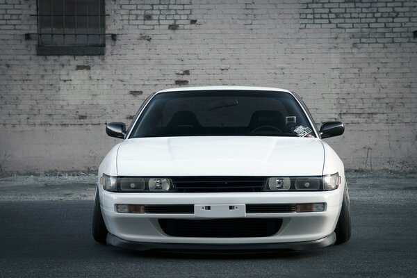 White car on the background of a brick wall