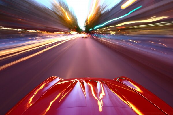 Un coche deportivo rojo corre por una pista borrosa en la foto