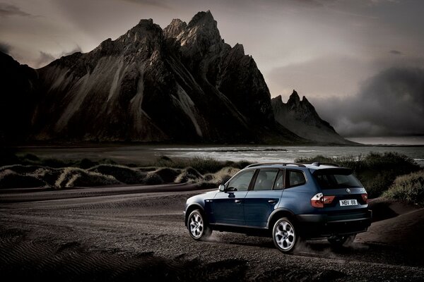 Monochrome landscape with a blue car