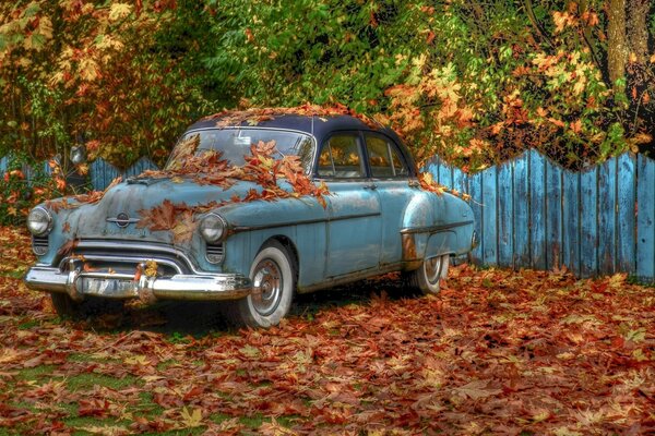 Ein Retro-Auto in einer Dorfstraße. Herbst außerhalb der Stadt