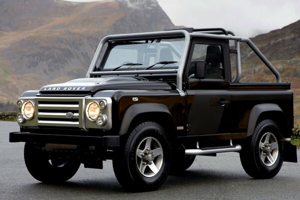 Land Rover negro en el fondo de las montañas