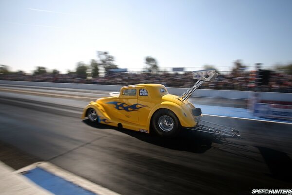 Coche retro amarillo volando por la pista