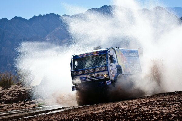 Das KamAZ-Auto jagt durch eine riesige Pfütze und erzeugt einen Spritzer Wasser