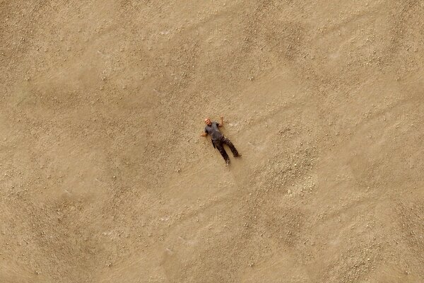 Ein Mann liegt im Sand