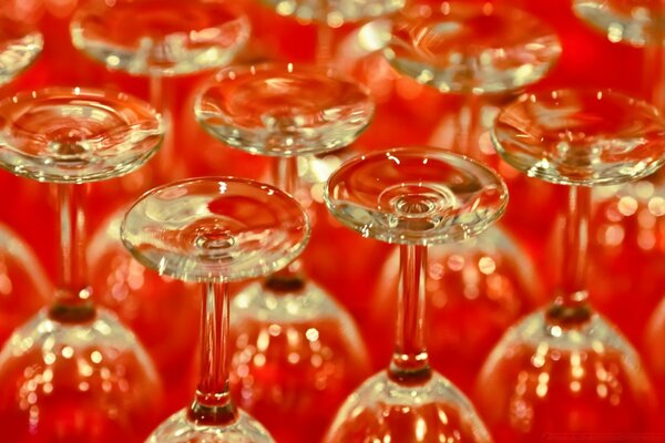 Copas de vino al revés transparentes sobre la mesa roja