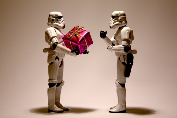 Robot figures from the movie Star Wars with a gift in their hands