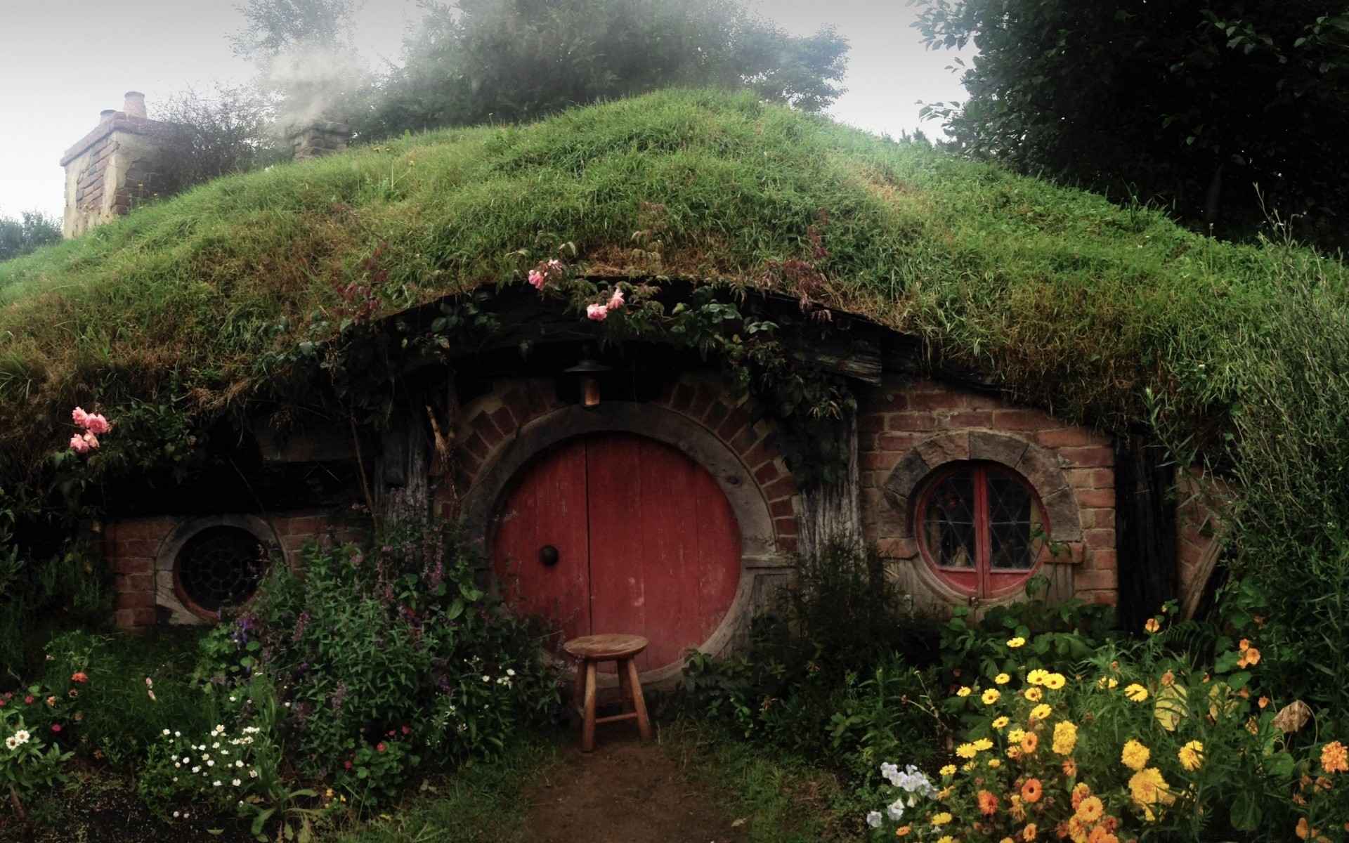 hobbit casa jardín viajes arquitectura madera casa paisaje árbol flor montañas verano al aire libre hogar naturaleza