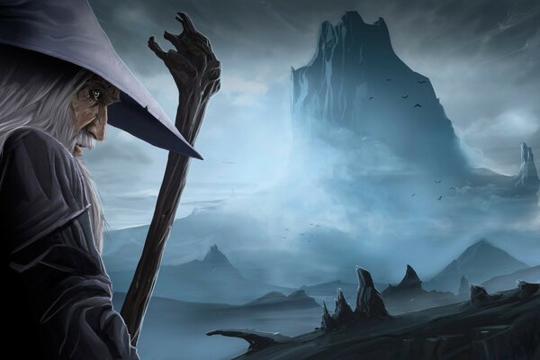 An old man with a beard and a staff against the background of mountains in the fog