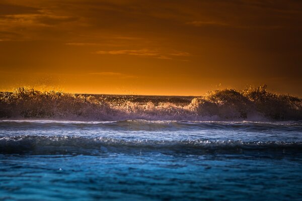 Raging waves on the background of sunset