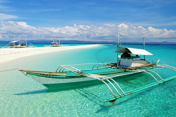 Bateau sur la plage tropicale de sable blanc