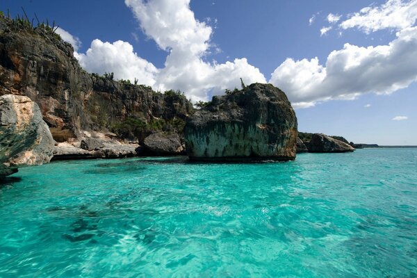 Blue water at the rocks with clouds in the sky