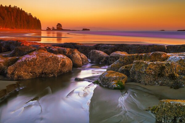 Water flowing through the stones, against the background of sunset