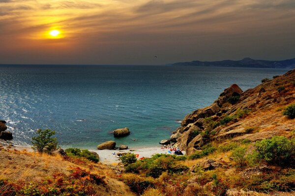 Hermosa pendiente junto al mar al atardecer