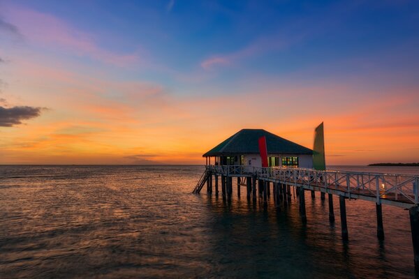 Belle vue du coucher du soleil. Maison au - dessus de l eau de l océan