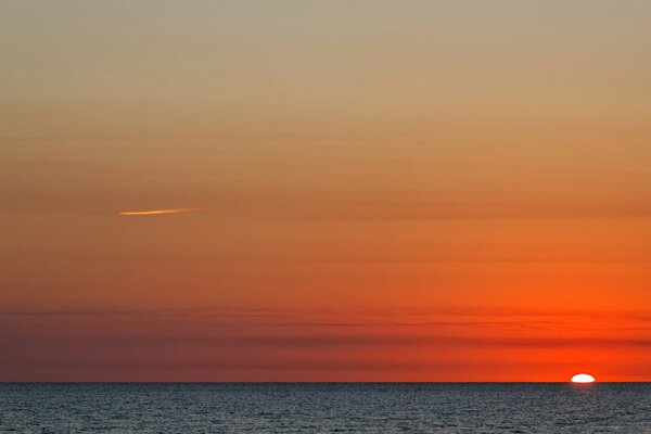 Amanecer rojo brillante en el mar