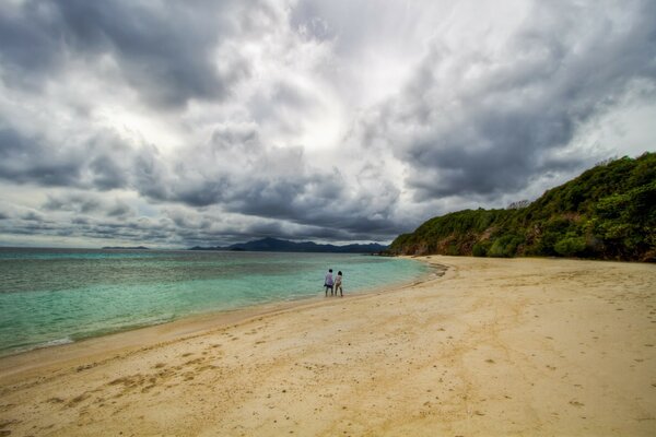 Two people walking on a wild beach