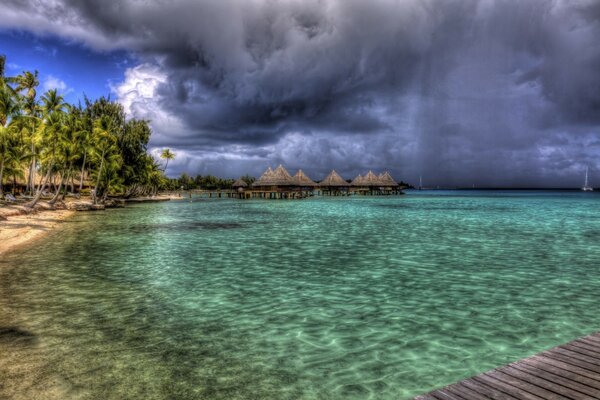 Tropischer Strand mit Bungalows am Meer