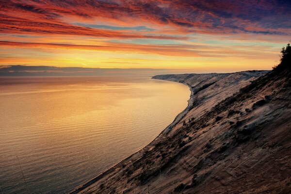 Curved shore and colorful evening sky