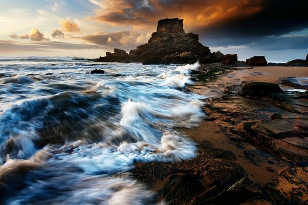 Alba su una spiaggia rocciosa bagnata dal mare