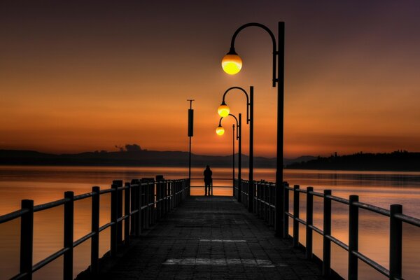 Hölzerner Pier mit Meerblick bei Sonnenuntergang des Tages