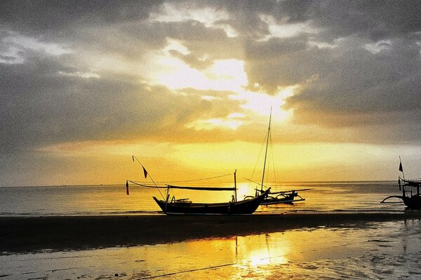 Image de la mer avec un bateau sur fond de coucher de soleil