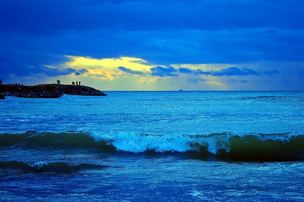 Sunset on a not calm sea. The approaching wave