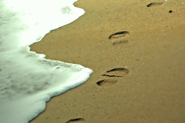 Traces humaines dans le sable au bord de la mer