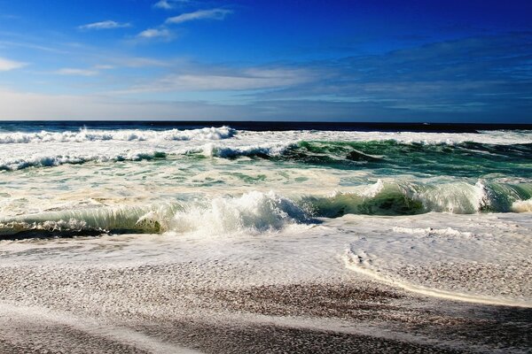 Meeresschaum und Wellen am Strand