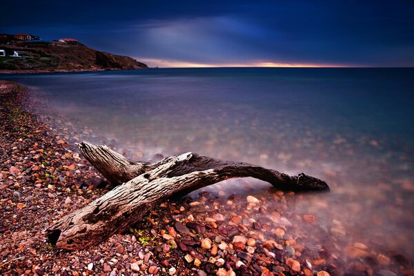 Puesta de sol, agua. Playa y guijarros