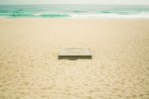 Eine im Sand vergrabene Kiste am Strand