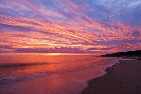 Encantador atardecer carmesí sobre el agua