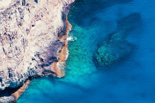 Pintura de um oceano azul com rochas íngremes