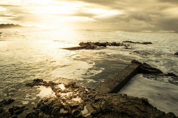 A picture of waves with reefs on the background of sunset