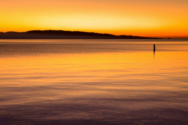 Heller Sonnenuntergang und ruhiges Meer