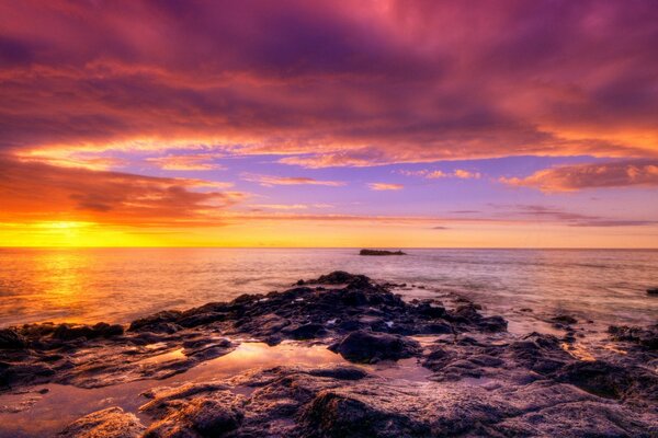 Sea on the background of dawn with stones