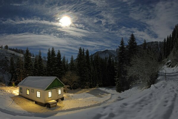 Noche de invierno, las ventanas se queman en una casa de madera