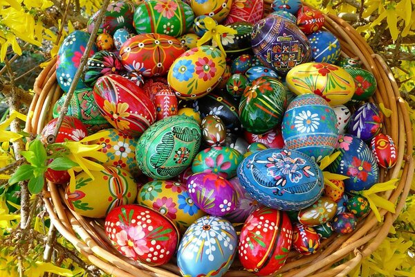 Wicker basket with Easter eggs on a yellow background