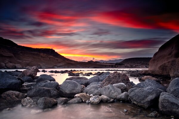 Puesta de sol sobre el mar y la costa rocosa