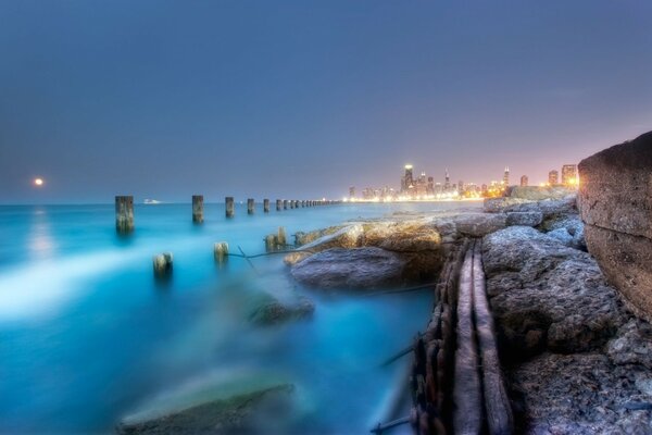 Foggy pier on the background of a glowing city