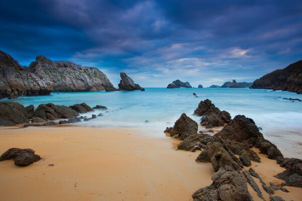 Sandy beach on the background of mountains and sky