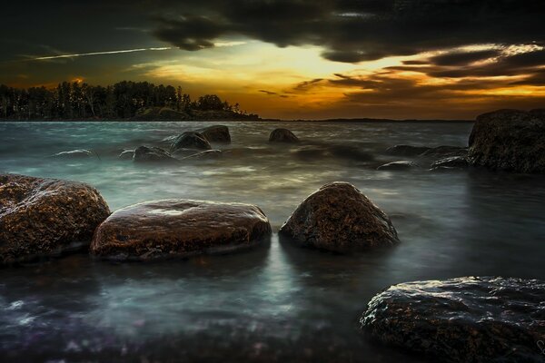 Coastal cliffs and a sea island in the distance against the sunset