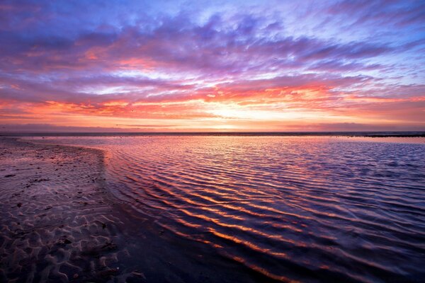 Puesta de sol rosa en el cielo azul sobre el mar